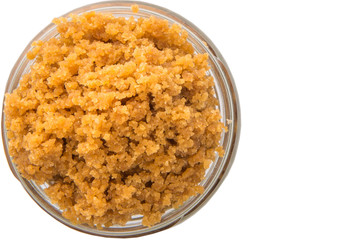 Grated Coconut sugar in a glass container over white background