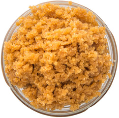 Grated Coconut sugar in a glass container over white background