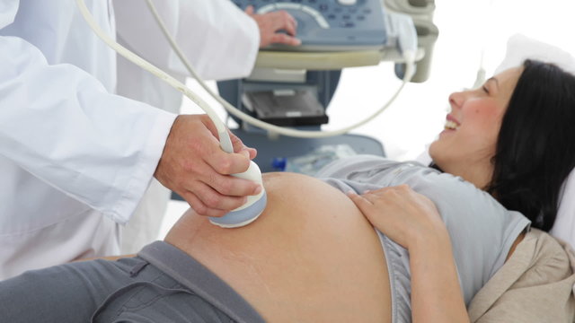 Brunette pregnant woman having a sonogram scan