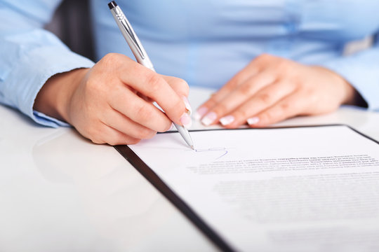 Young woman signs a contract