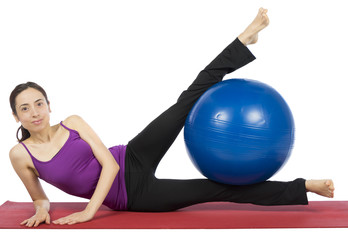 Fitness woman exercising her legs with a pilates ball