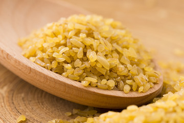 bulgur wheat in wooden spoon