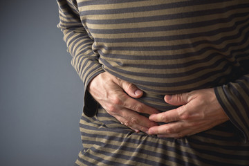 Abdominal Pain. Man holds his stomach and has hurt
