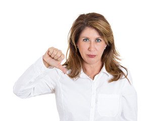 Middle aged woman giving thumbs down gesture, white background