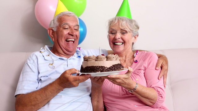 Senior couple celebrating a birthday on the couch