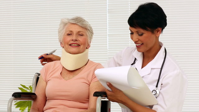 Nurse talking with elderly patient in a wheelchair