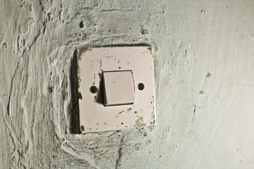 Old light switch on old green wall