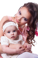 mother in a pink dress with a daughter 6 months in white dress