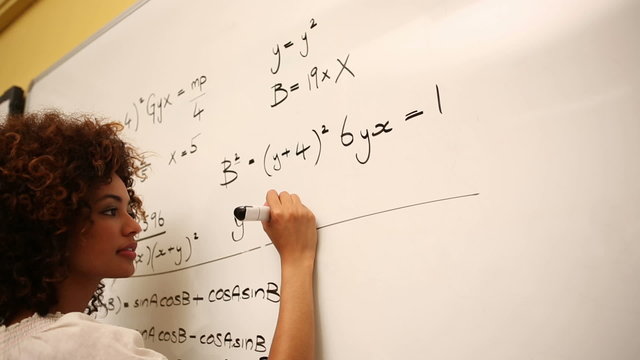 Clever student solving math problems on whiteboard