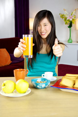 Obraz na płótnie Canvas Asian woman having healthy breakfast with fruit and orange juice