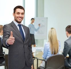 handsome buisnessman showing thumbs up in office