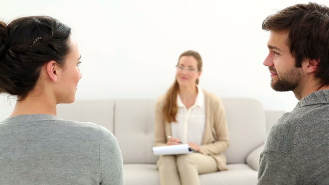 Therapist smiling at reconciled couple