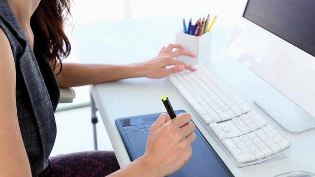 Graphic designer working on digitizer at her desk