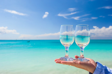 Two clean glasses on background of turquoise sea