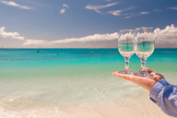 Two wine glasses on background of turquoise sea
