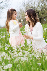 Mother and daughter in field with dandelions