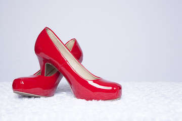 Red Patent Leather Pumps on a White Faux Fur Surface with White Background