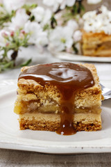 Pouring caramel sauce on piece of apple pie
