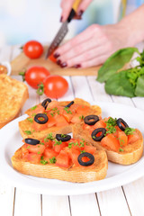Delicious bruschetta with tomatoes on plate on table close-up