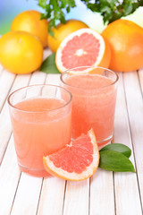 Ripe grapefruit with juice on table close-up