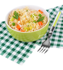 Tasty instant noodles with vegetables in bowl on table close-up