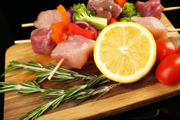Raw pork kebab on black background