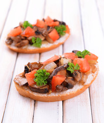 Delicious bruschetta with mushrooms on table close-up