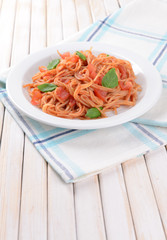 Pasta with tomato sauce on plate on table close-up