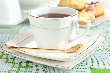 Cup of tea with sweet pastries on table close-up