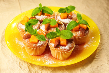 Tasty pumpkin muffins on brown paper