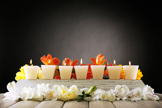 Fototapeta Beautiful candles with flowers on wooden background