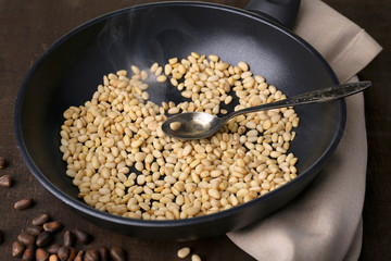Cedar pine nuts on pan, on wooden table