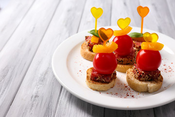 Tasty canapes with salami,tomato, pepper  and basil leaves,