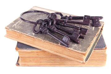 Old keys on old books isolated on white