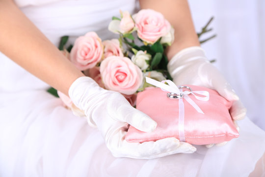 Bride in gloves holding wedding bouquet, close-up