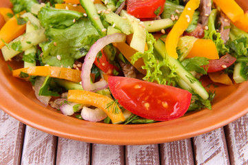 Beef salad on plate on wooden background