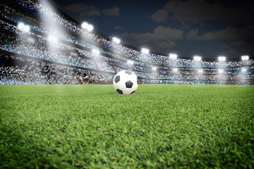 Soccer ball on field in stadium at night