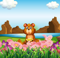 Obraz na płótnie Canvas A cute bear near the flowers at the riverbank