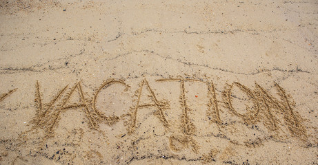 The VACATION word written on beach sand 