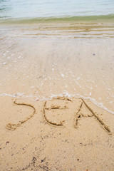 Beach with the word SEA written on the sand 