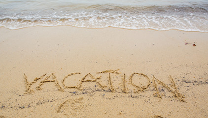 The VACATION word written on beach sand 