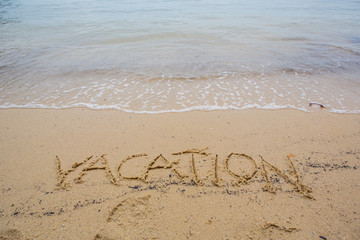 The VACATION word written on beach sand 