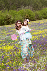 Mother and daughter in field with colorful flowers