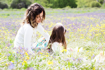 Mother and daughter in field with colorful flowers