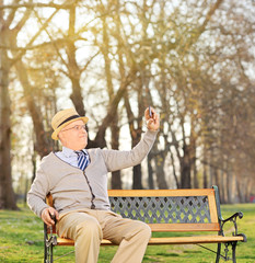 Senior adult taking a selfie in park