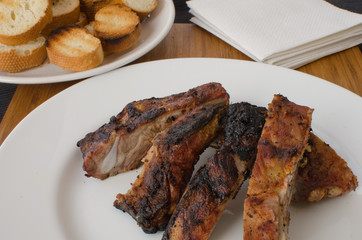 Spareribs on grill with dip and toasted baguette
