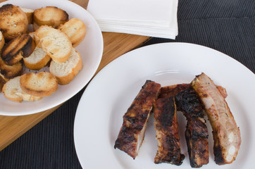 Spareribs on grill with dip and toasted baguette