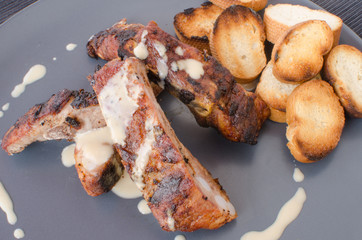 Spareribs on grill with dip and toasted baguette