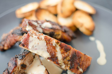 Spareribs on grill with dip and toasted baguette