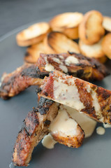 Spareribs on grill with dip and toasted baguette